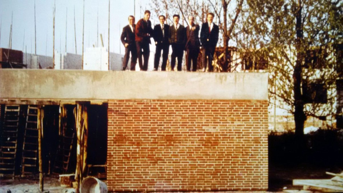 Richtfest – Mitglieder stehen stolz auf dem Rohbau